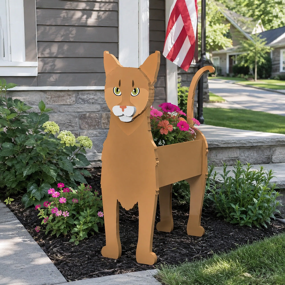 Abyssinian cat planter filled with fresh flowers is placed in the garden