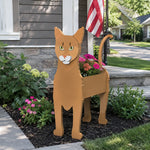 Abyssinian cat planter filled with fresh flowers is placed in the garden