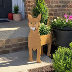 Abyssinian cat planter filled with fresh flowers is placed in the garden