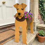 Airedale Terrier dog planter filled with fresh flowers is placed in the garden