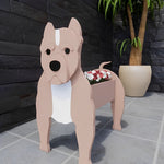 American Staffordshire Terrier dog planter filled with fresh flowers is placed in the garden