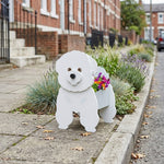 Bichon Friese dog planter filled with fresh flowers is placed in the garden