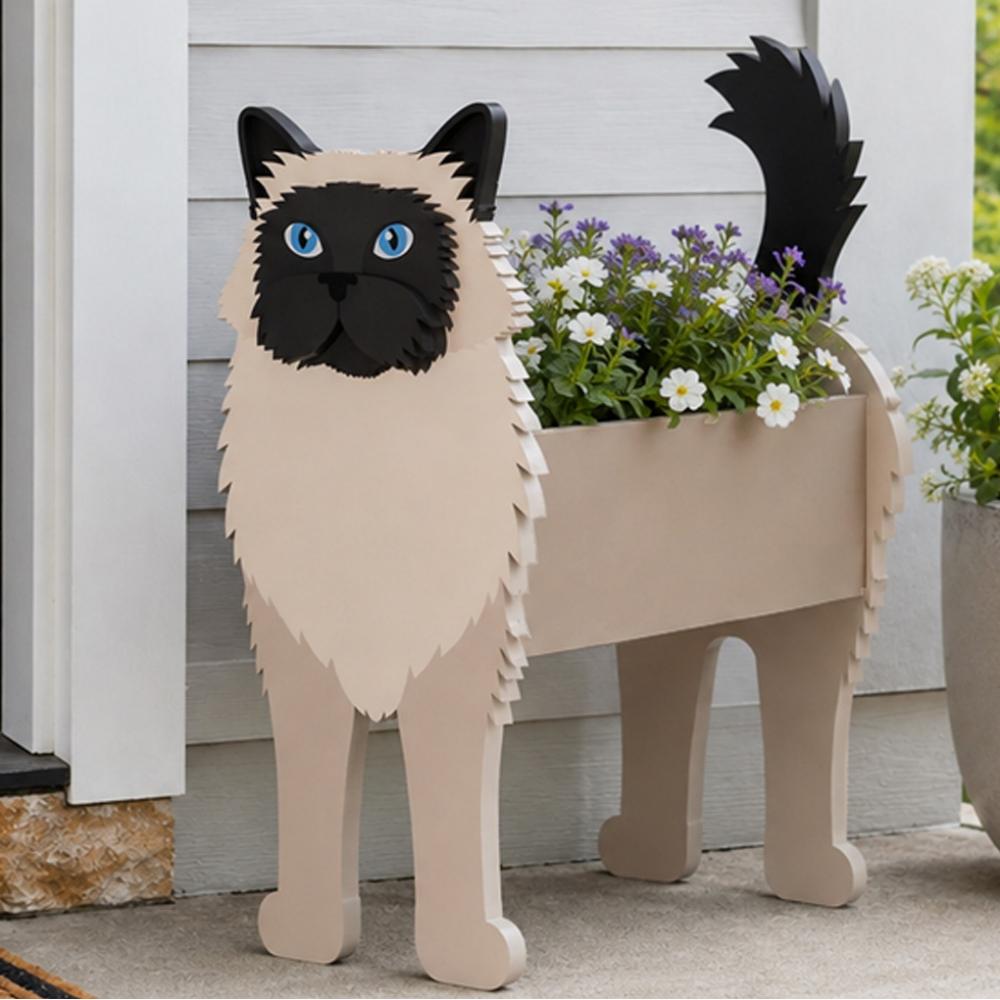 Birman cat planter filled with fresh flowers is placed in the garden