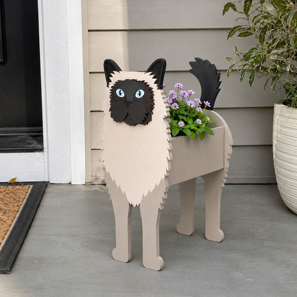 Birman cat planter filled with fresh flowers is placed in the garden
