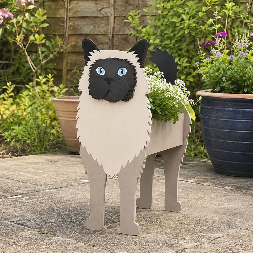 Birman cat planter filled with fresh flowers is placed in the garden