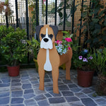 Boxer dog planter filled with fresh flowers is placed in the garden