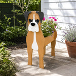 Boxer dog planter filled with fresh flowers is placed in the garden