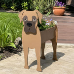 Boxer dog planter filled with fresh flowers is placed in the garden