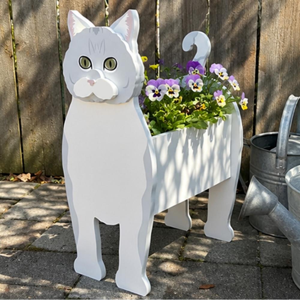 British shorthair cat planter filled with fresh flowers is placed in the garden