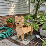 Cairn Terrier dog planter filled with fresh flowers is placed in the garden