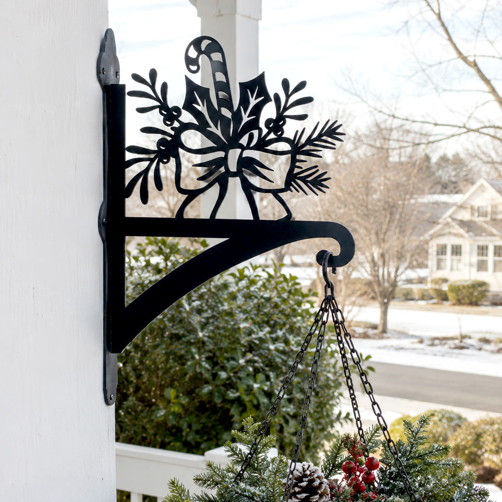 Candy cane and holly metal hanging basket bracket mounted on outdoor wall for plant decoration