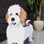 Cavachon dog planter filled with fresh flowers is placed in the garden