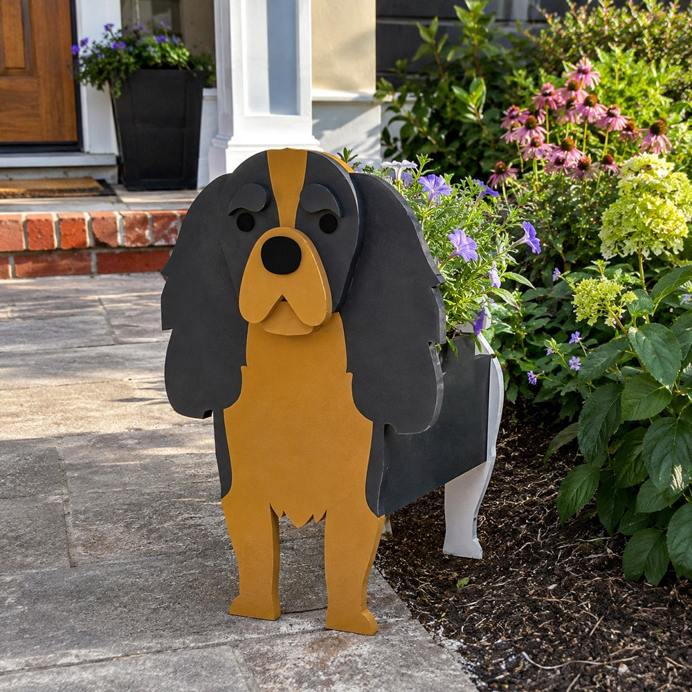 Cavalier King Charles Spaniel dog planter filled with fresh flowers is placed in the garden.
