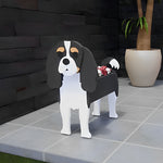 Cavalier King Charles Spaniel dog planter filled with fresh flowers is placed in the garden.