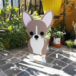 Chihuahua dog planter filled with fresh flowers is placed in the garden