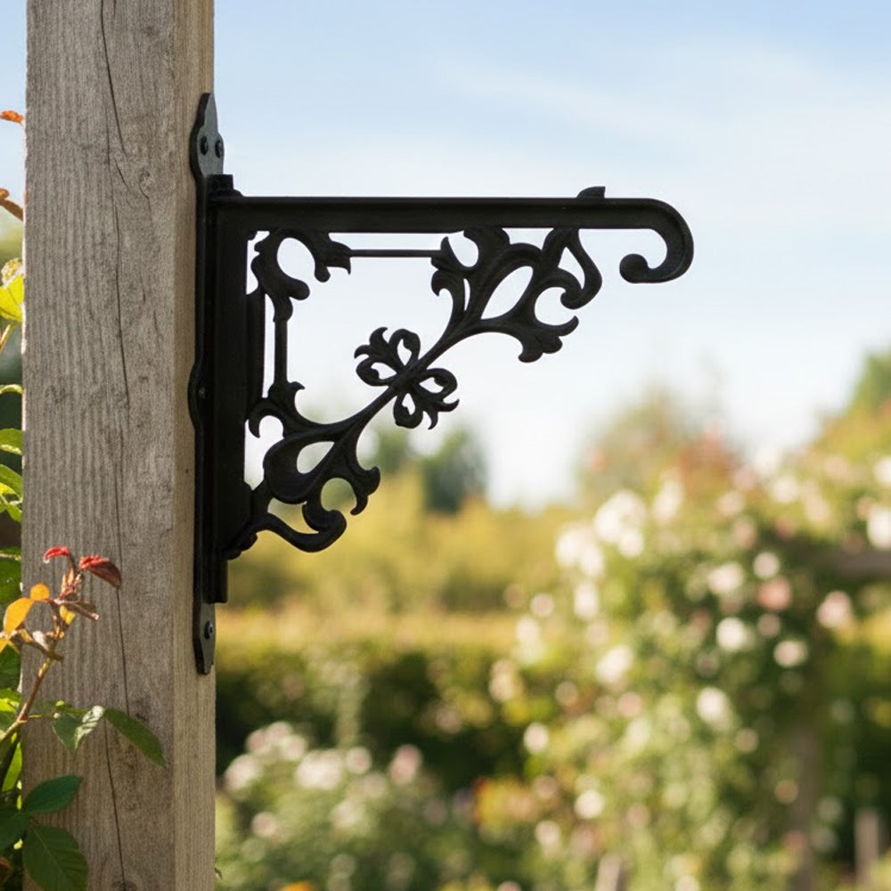 Classic baroque scrollwork metal hanging basket bracket mounted on outdoor wall for plant decoration
