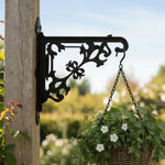 Classic baroque scrollwork metal hanging basket bracket mounted on outdoor wall for plant decoration