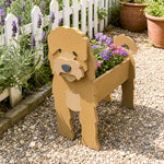 Cockapoo dog planter filled with fresh flowers is placed in the garden