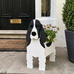 Cocker Spaniel dog planter filled with fresh flowers is placed in the garden