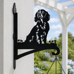 Cocker spaniel metal hanging basket bracket mounted on outdoor wall for plant decoration