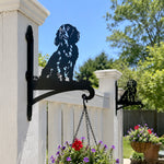 Cocker spaniel metal hanging basket bracket mounted on outdoor wall for plant decoration