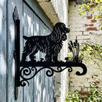 Cocker spaniel metal hanging basket bracket mounted on outdoor wall for plant decoration