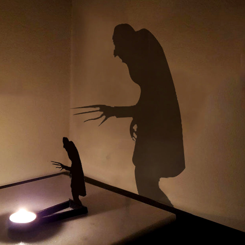 Creeping zombie halloween metal candle holder casting a spooky shadow on the wall