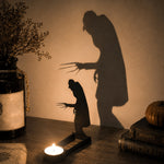 Creeping zombie halloween metal candle holder casting a spooky shadow on the wall