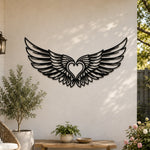Black metal Cupid Heart wings wall art with intricate cutout details displayed on the wall