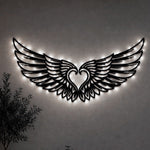 Black metal Cupid Heart wings wall art with Soft White LED Lighting displayed on the wall