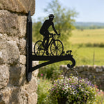 Cyclist riding road bike metal hanging basket bracket mounted on outdoor wall for plant decoration