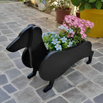 Dachshund dog planter filled with fresh flowers is placed in the garden