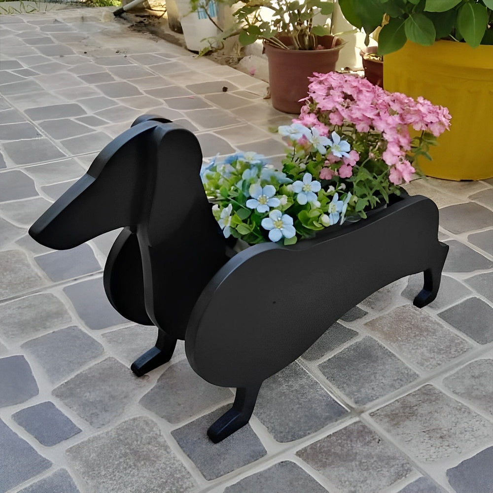 Dachshund dog planter filled with fresh flowers is placed in the garden