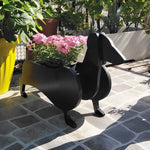 Dachshund dog planter filled with fresh flowers is placed in the garden