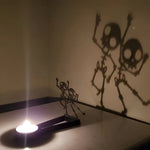 Dancing skeletons halloween metal candle holder casting a spooky shadow on the wall
