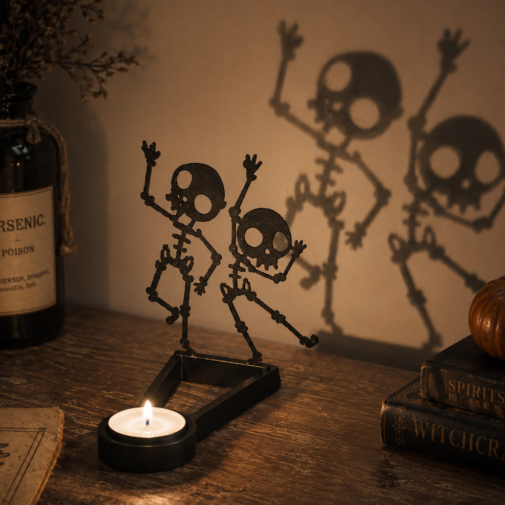 Dancing skeletons halloween metal candle holder casting a spooky shadow on the wall