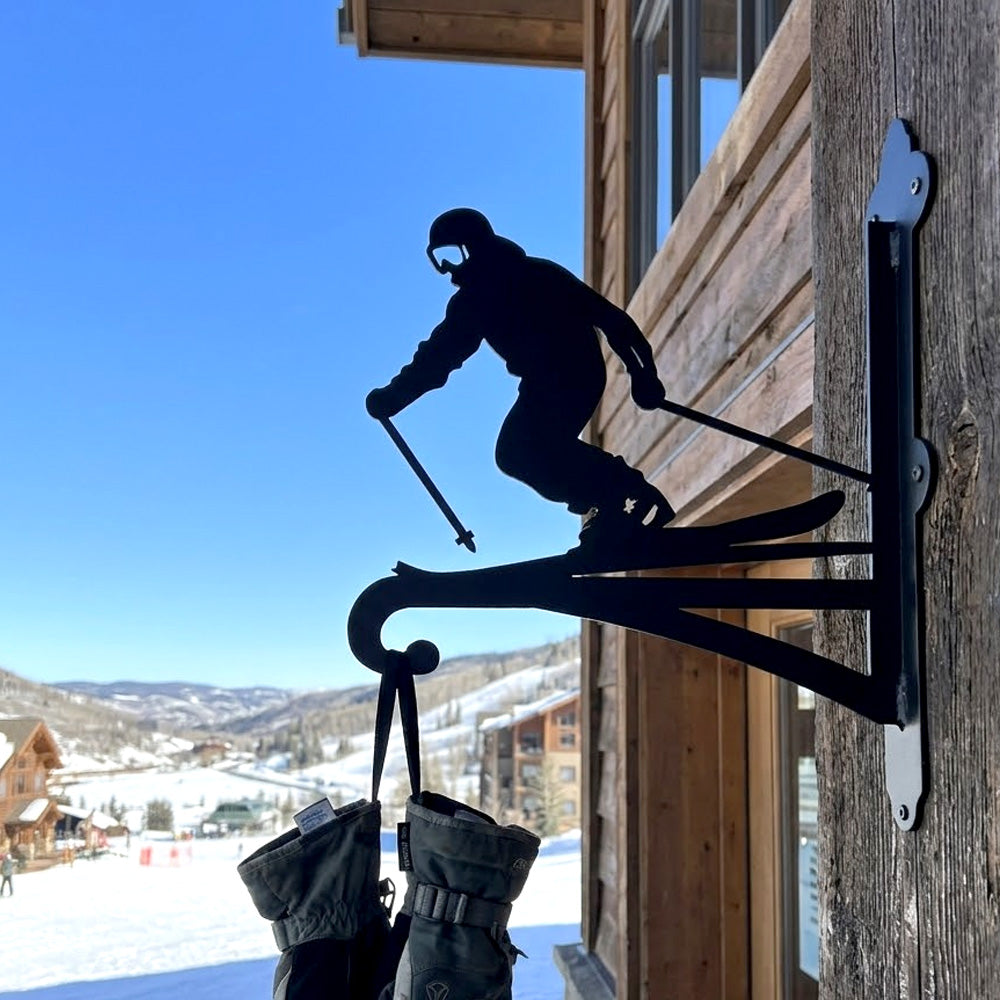 Downhill skier metal hanging basket bracket mounted on outdoor wall for plant decoration