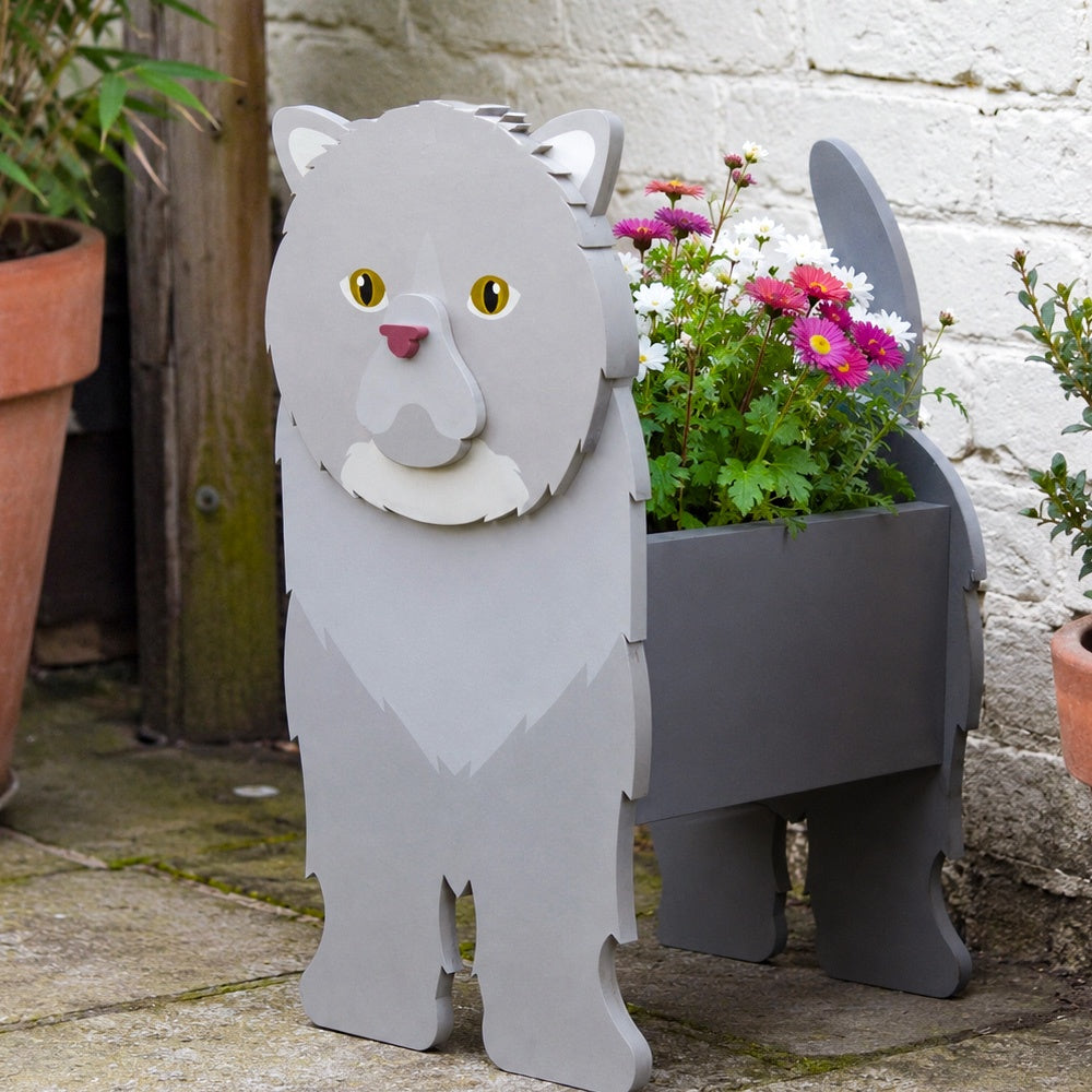Exotic Shorthair cat planter filled with fresh flowers is placed in the garden