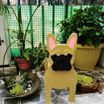 French Bulldog planter filled with fresh flowers is placed in the garden.