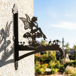 Garden fairy sitting on mushroom metal hanging basket bracket mounted on outdoor wall for plant decoration