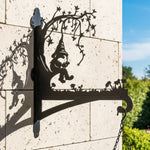 Garden gnome under tree metal hanging basket bracket mounted on outdoor wall for plant decoration