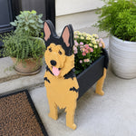 German Shepherd dog planter filled with fresh flowers is placed in the garden.