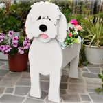 Goldendoodle dog planter filled with fresh flowers is placed in the garden