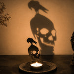 Graveyard skull halloween metal candle holder casting a spooky shadow on the wall