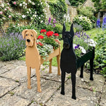 Great Dane dog planters filled with fresh flowers are placed in the garden.