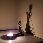 Haunted girl halloween metal candle holder casting a spooky shadow on the wall