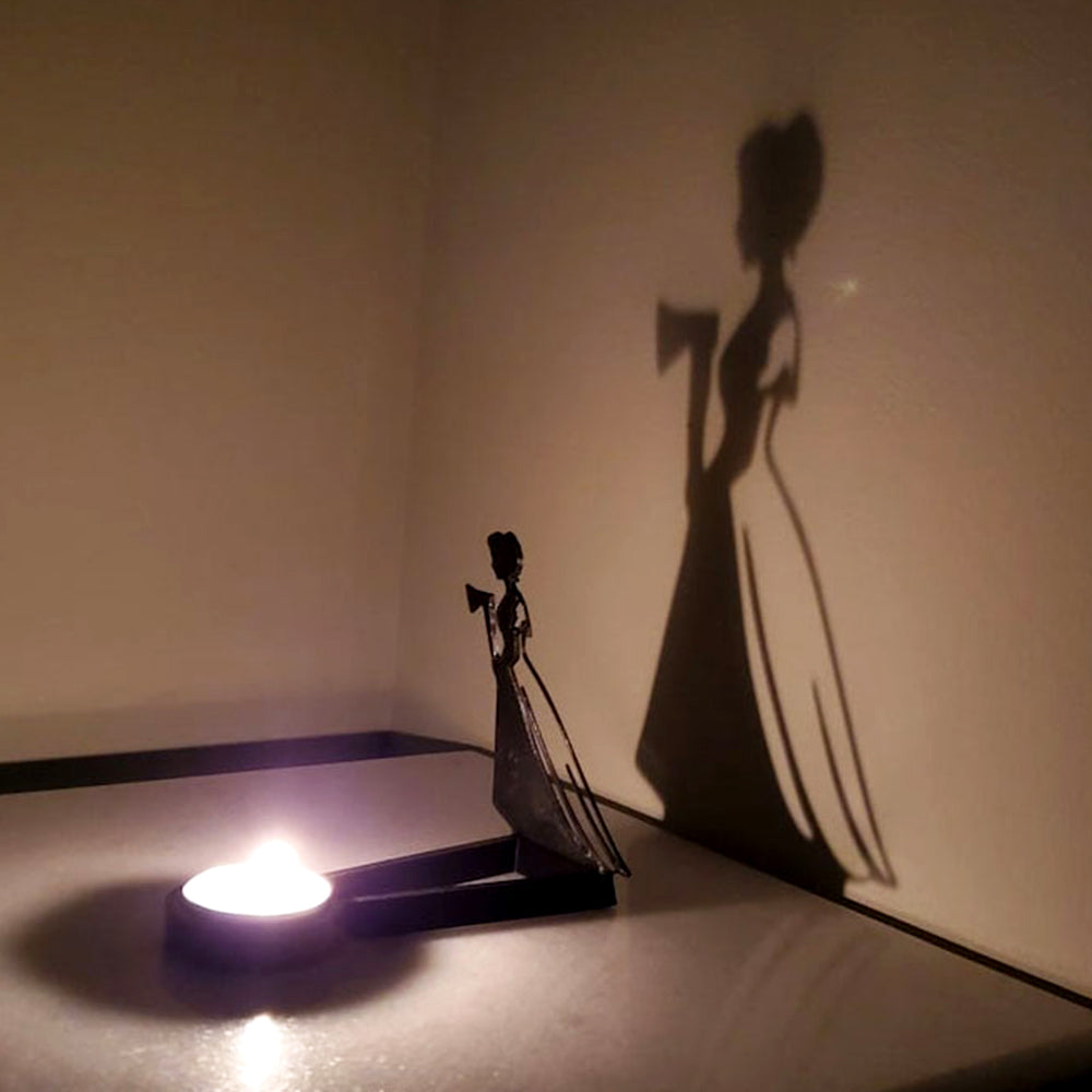 Haunted girl halloween metal candle holder casting a spooky shadow on the wall