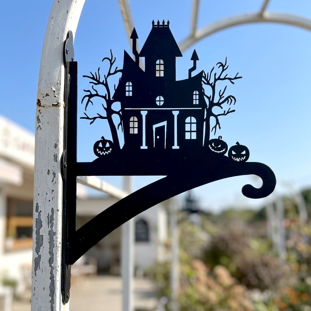 Haunted house metal hanging basket bracket mounted on outdoor wall for plant decoration