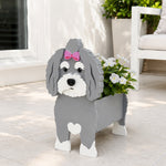 Havanese dog planter filled with fresh flowers is placed in the garden