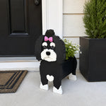 Havanese dog planter filled with fresh flowers is placed in the garden